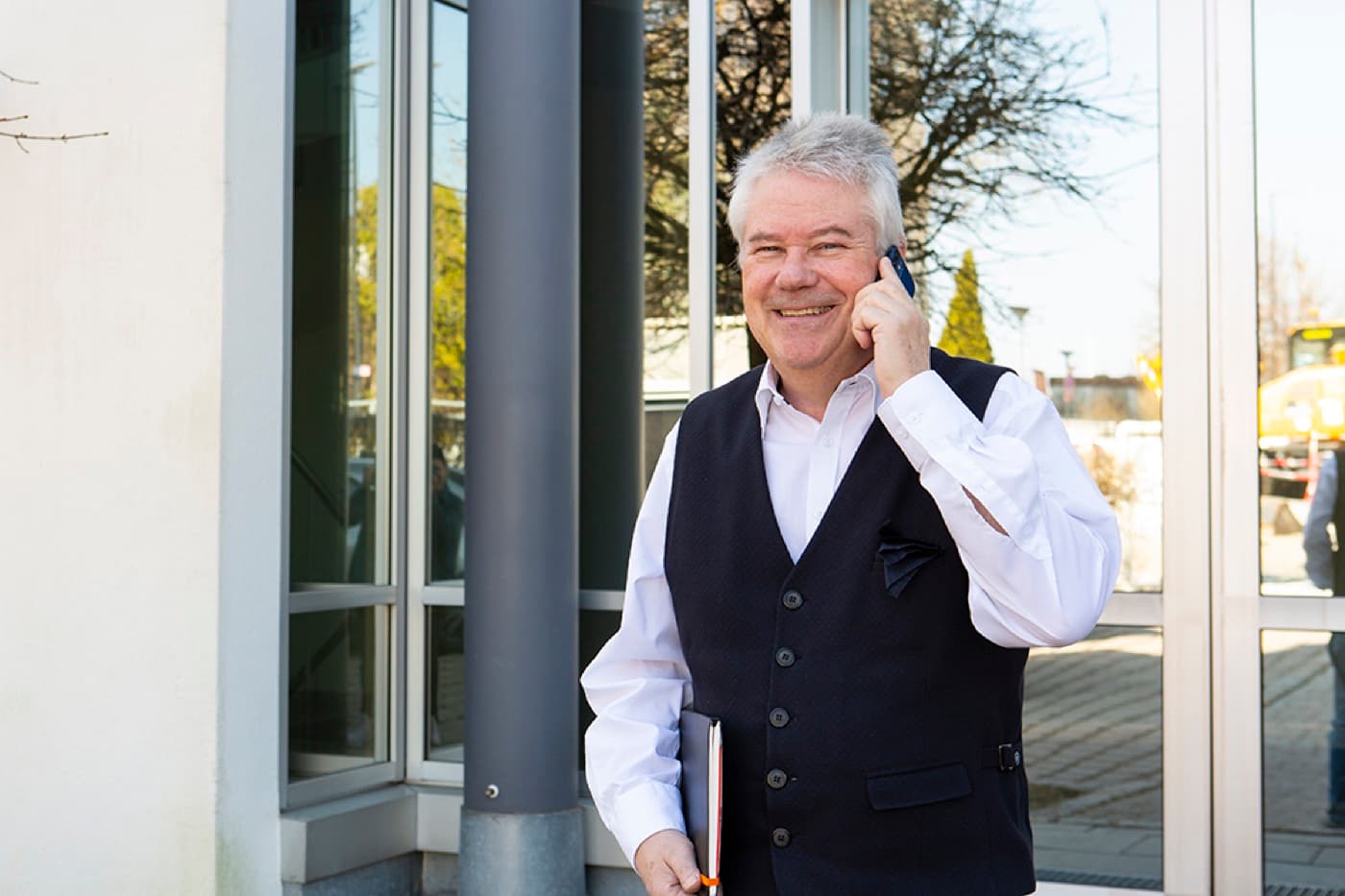 Stefan Rath im Telefonat vor dem Bürogebäude